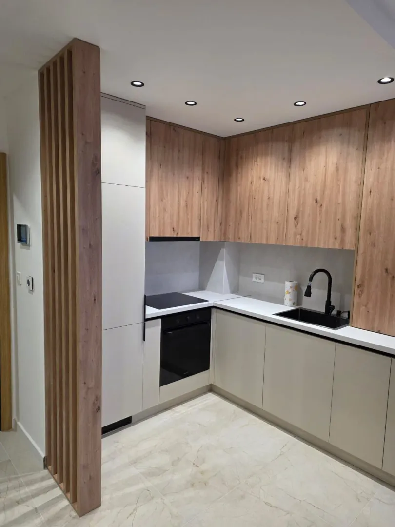 Modern kitchen with wooden elements and built-in appliances.