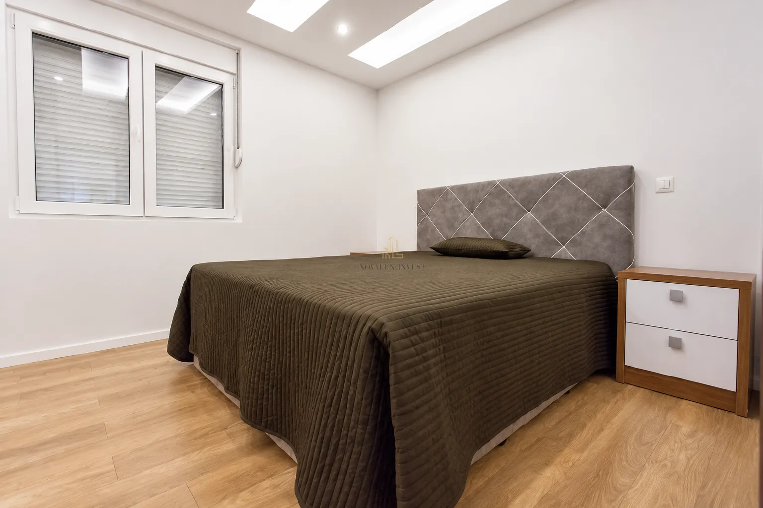 Modern bedroom with a double bed and a nightstand.