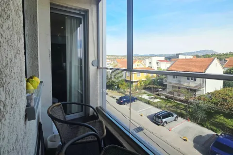 Manji zastakljeni balkon sa staklenom ogradom i pogledom na naselje i parking. - image 6