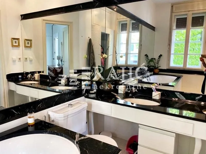 Spacious bathroom with double vanity and large mirror.