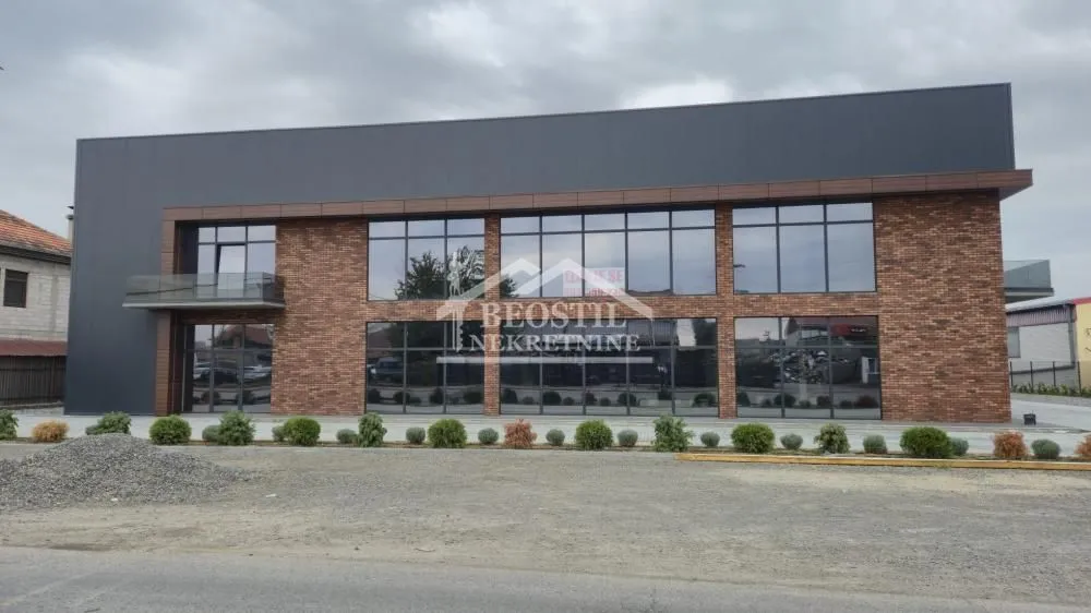 Exterior view of a commercial building with large glass surfaces and a brick facade.