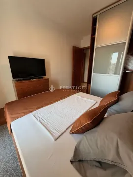 Furnished bedroom with a double bed, wardrobe, and chest of drawers with a TV. - image 9