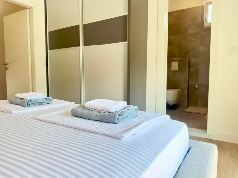 Furnished bedroom with a double bed and a view of the bathroom. - image 8