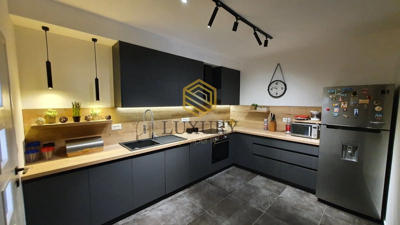 Modern kitchen with dark cabinets and wooden countertops.