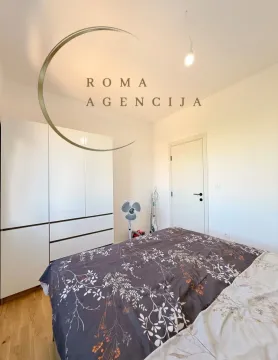 Bedroom with a double bed, white wardrobe, and a door. - image 6