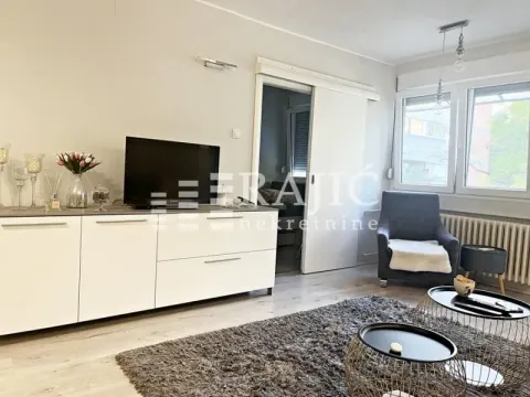 Living room with a TV unit, television, and an armchair. - image 3