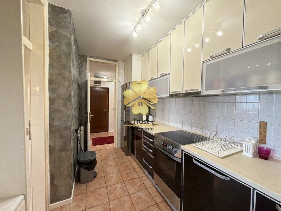 Small equipped kitchen with white and dark cabinets.