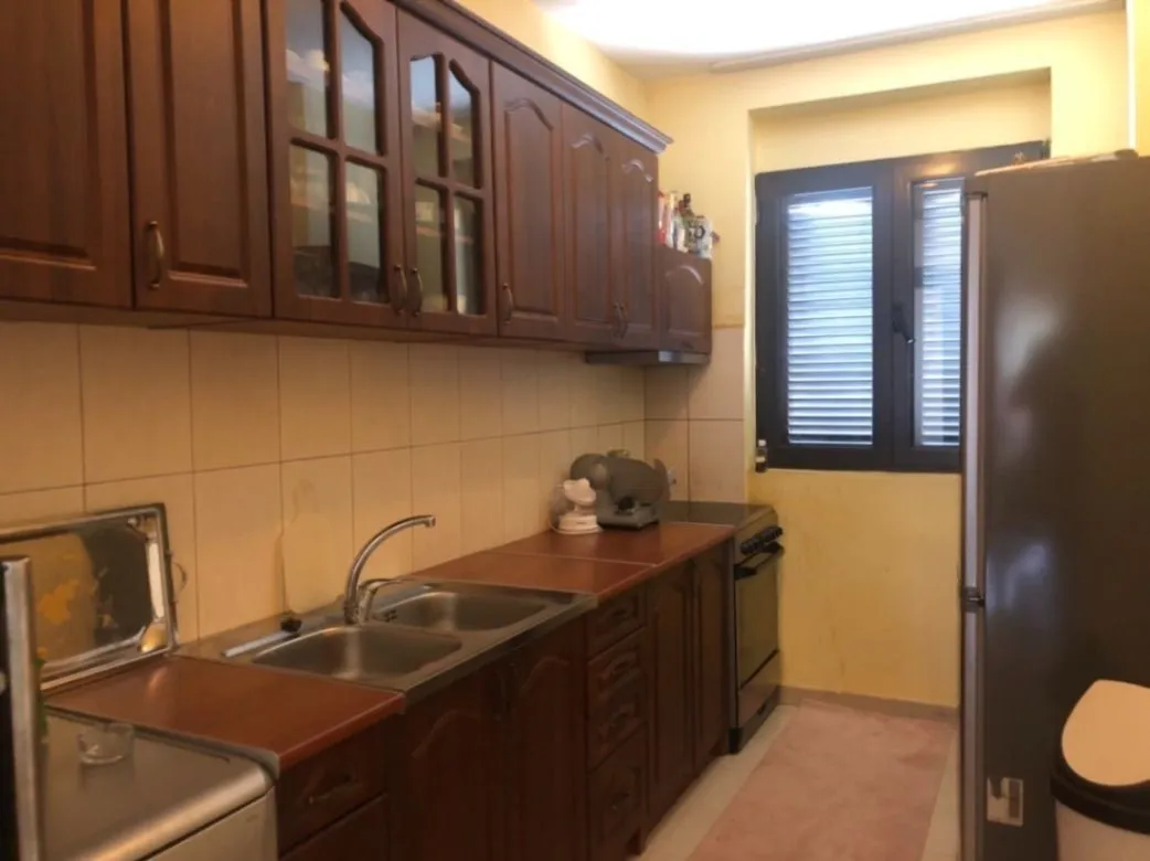A simple kitchen with wooden cabinets and a double sink.