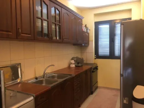 A simple kitchen with wooden cabinets and a double sink. - image 4