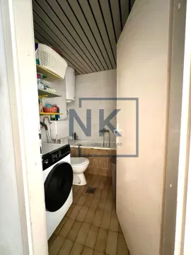 Pogled na kupatilo sa kadom, toaletom i mašinom za veš kroz otvorena vrata. - image 9