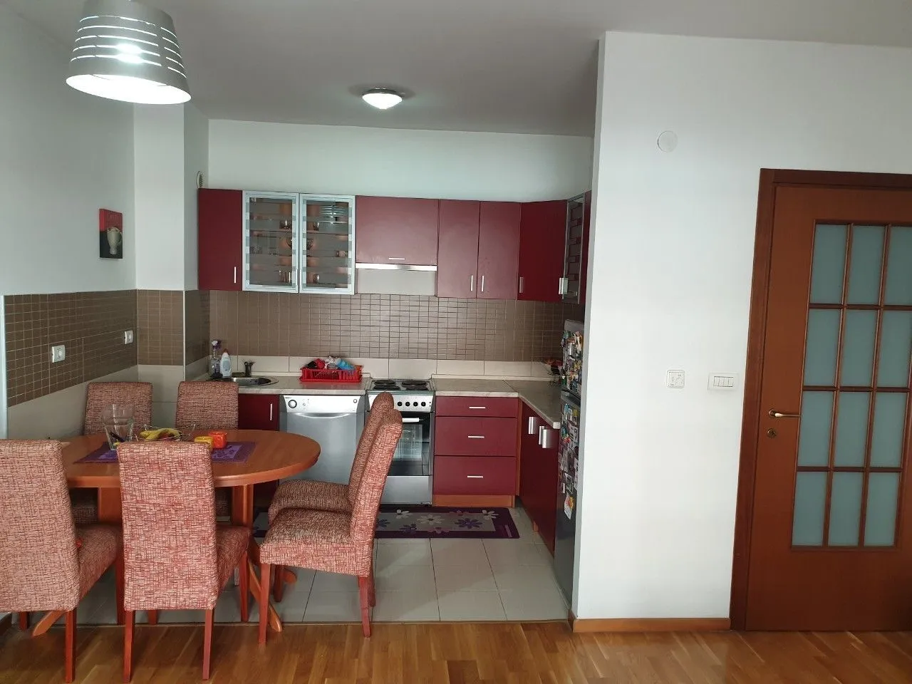 Kitchen with a dining table and red kitchen cabinets.