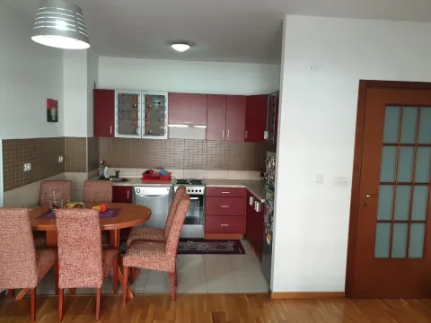 Kitchen with a dining table and red kitchen cabinets. - image 3