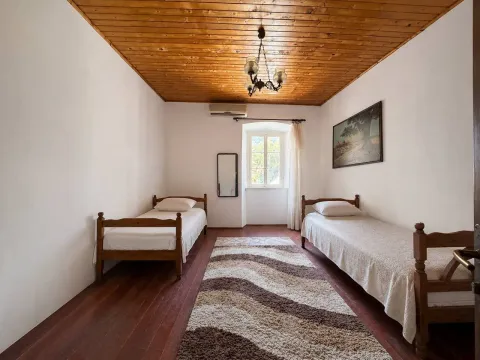 Spavaća soba sa dva drvena kreveta i drvenim plafonom. - image 2