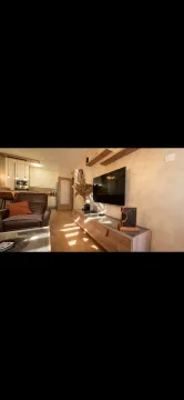 Living room with sofa, TV, and a view toward the kitchen. - image 7