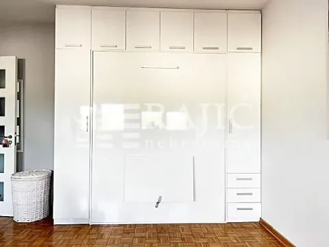 Bedroom with built-in wardrobes and a wall bed. - image 7