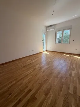 Prazna soba sa parketom, klima-uređajem i izlazom na terasu. - image 2