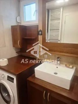 Kupatilo sa umivaonikom, drvenim elementima i veš mašinom. - image 18