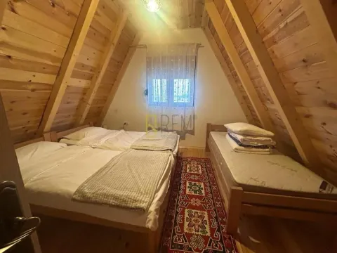 Potkrovna spavaća soba sa drvenim oblogama i dva kreveta. - image 5