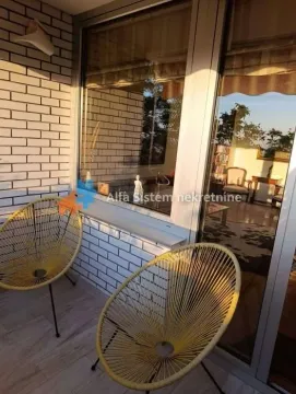 Natkrivena terasa sa dve žute stolice i pogledom na unutrašnjost. - image 18