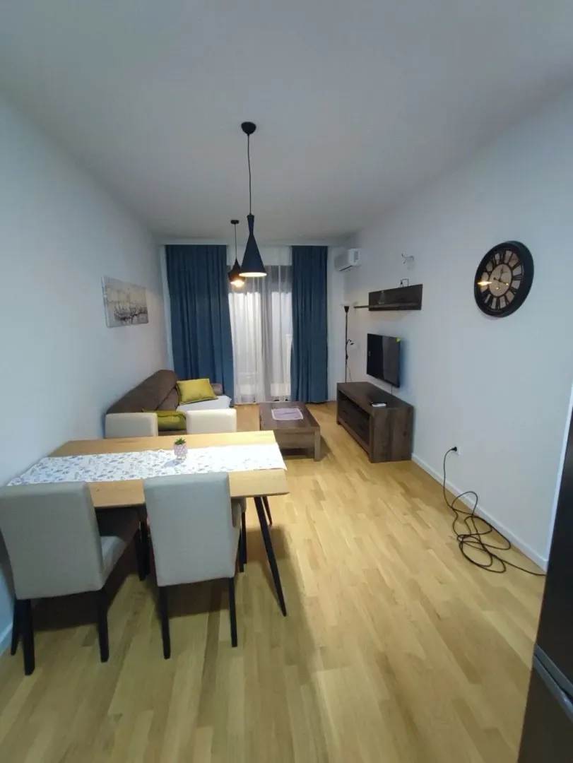 Dnevni boravak sa trpezarijom, garniturom i televizorom.