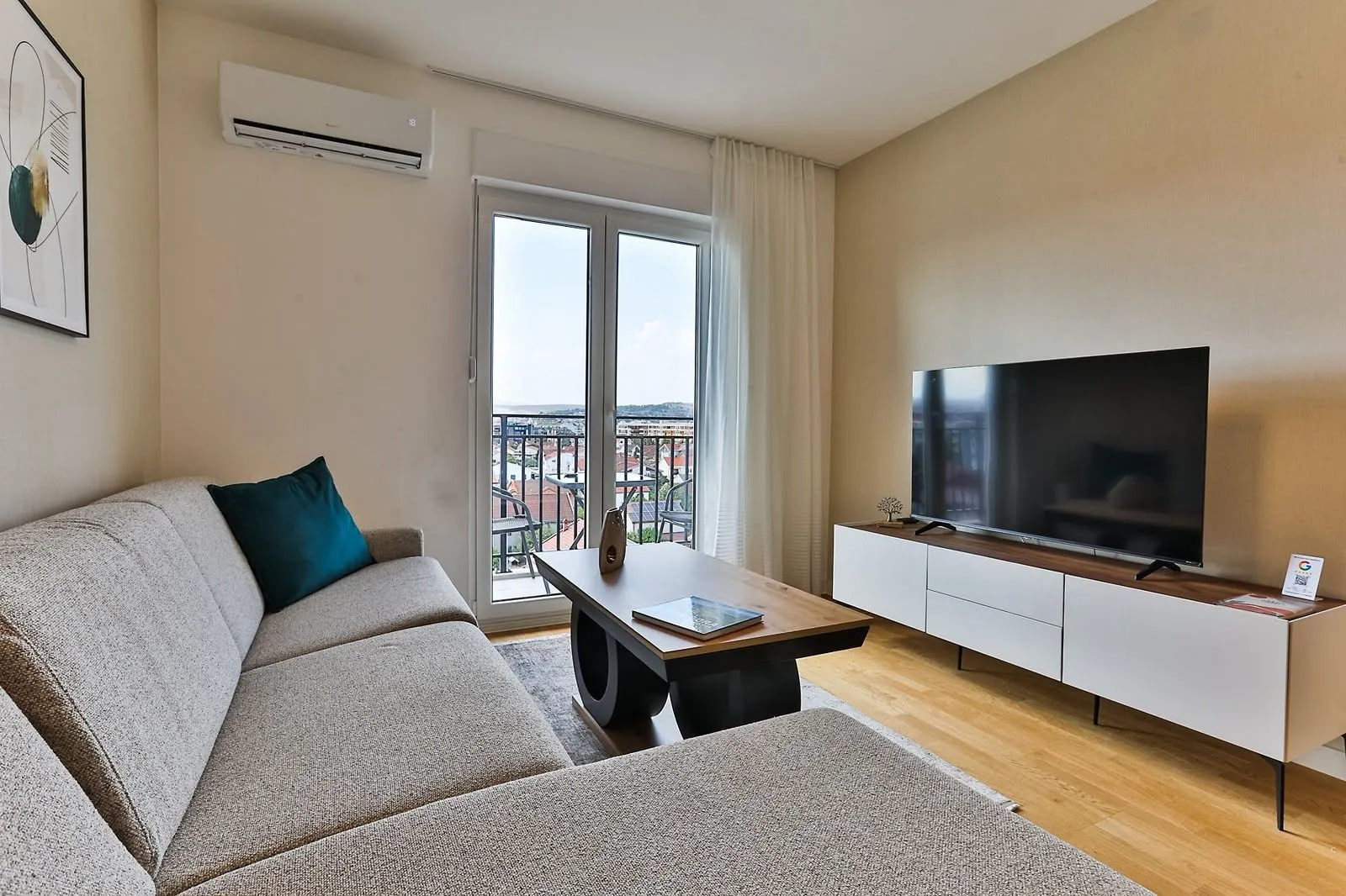Furnished living room with a sofa, television, and access to the terrace.