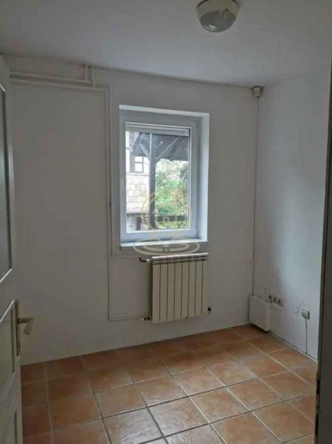 Empty room with tiled flooring and a single window.