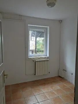 Empty room with tiled flooring and a single window. - image 8