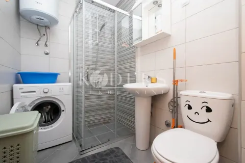 Kupatilo opremljeno tuš kabinom, umivaonikom, wc šoljom i mašinom za veš. - image 7