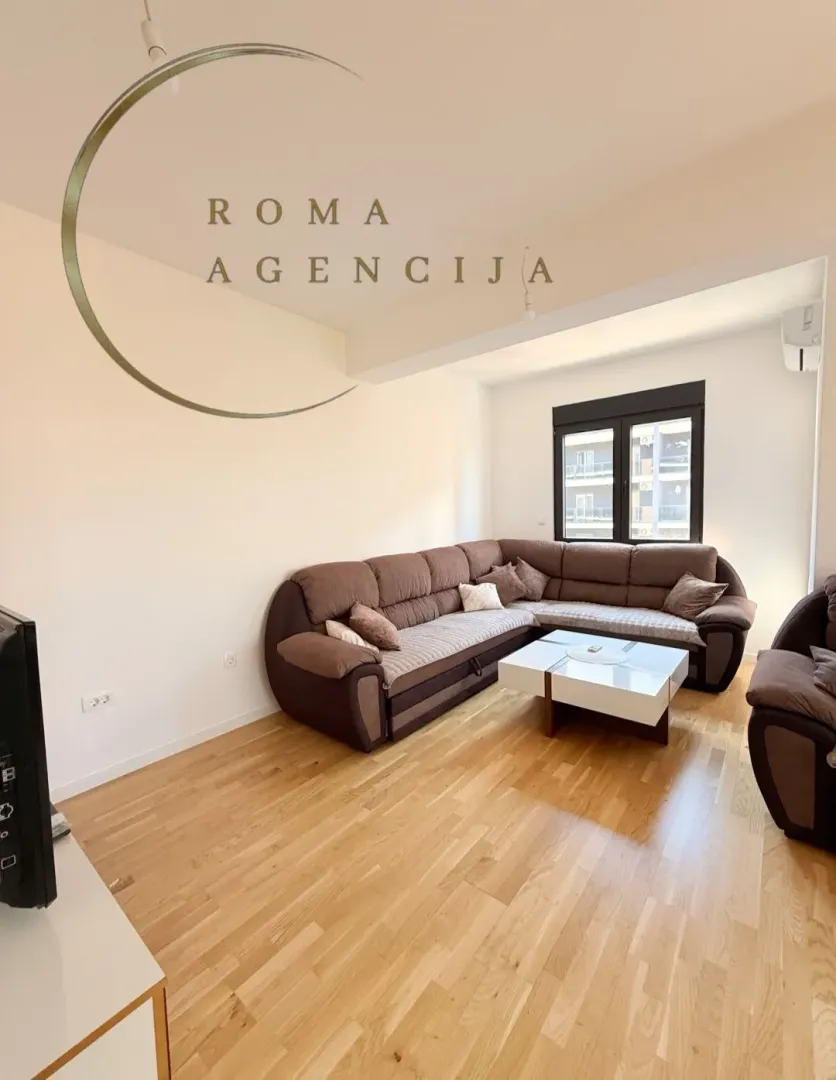 Living room with a sectional sofa and hardwood flooring.