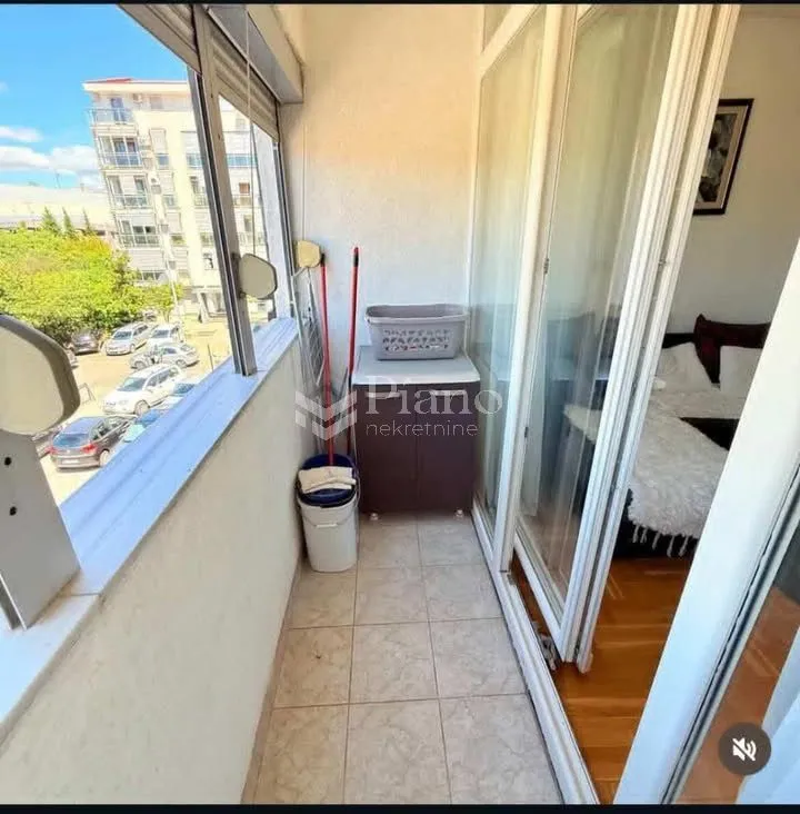 Small enclosed balcony with a view of the street and parking.