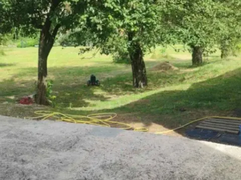 Pogled na prostrano dvorište sa travnjakom i drvećem. - image 2