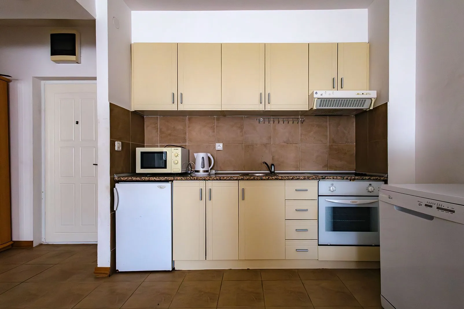 Kitchen with light cabinets and built-in home appliances.
