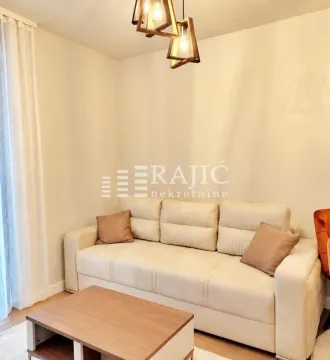 Dnevna soba sa svetlom garniturom i drvenim stočićem. - image 4