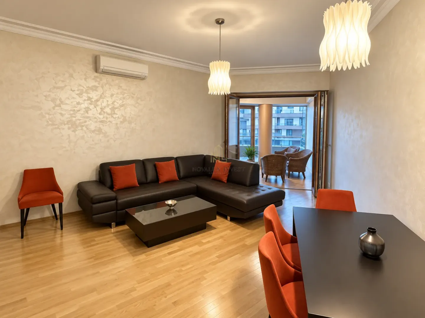 Spacious living room with a sofa set, dining table, and access to the terrace.
