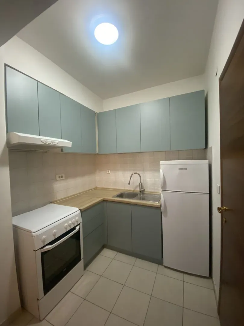 Small kitchen with grey-blue cabinets and appliances.