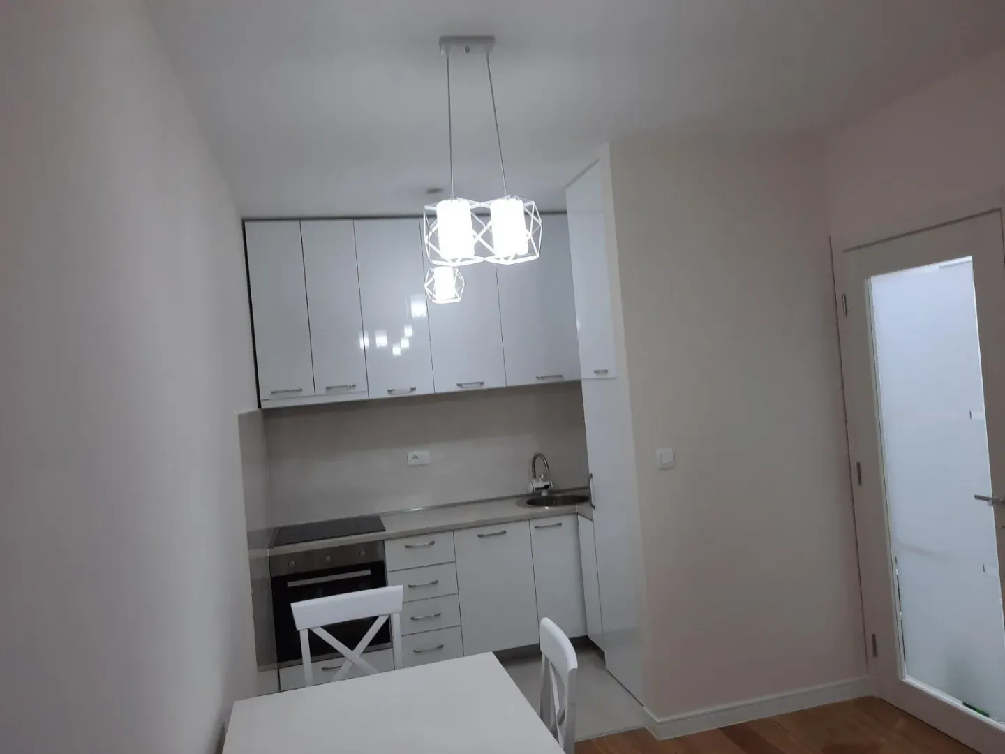 Bright and modern white kitchen with a dining table.