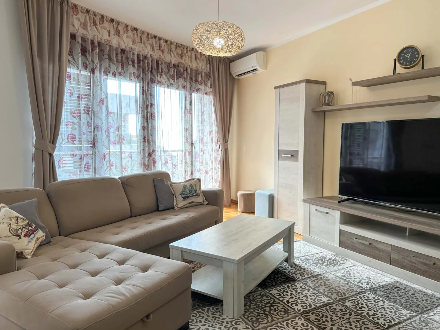 Bright living room with a sectional sofa, coffee table, and TV.