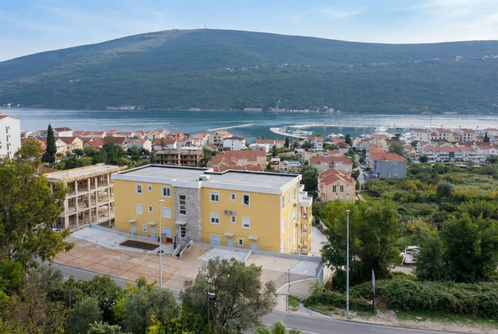 Žuta stambena zgrada u blizini mora sa pogledom na zaliv.