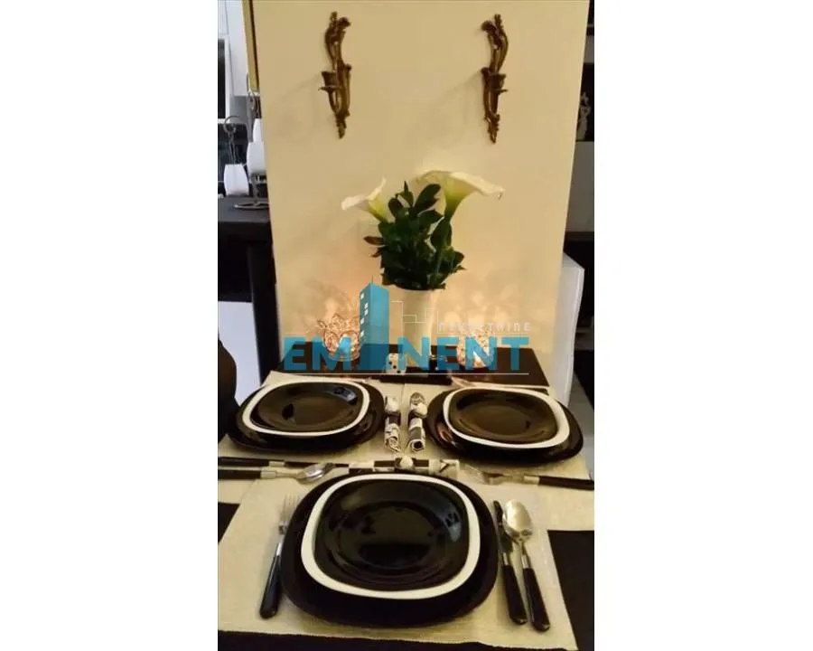 Set dining table with black plates and decorative details on the wall.