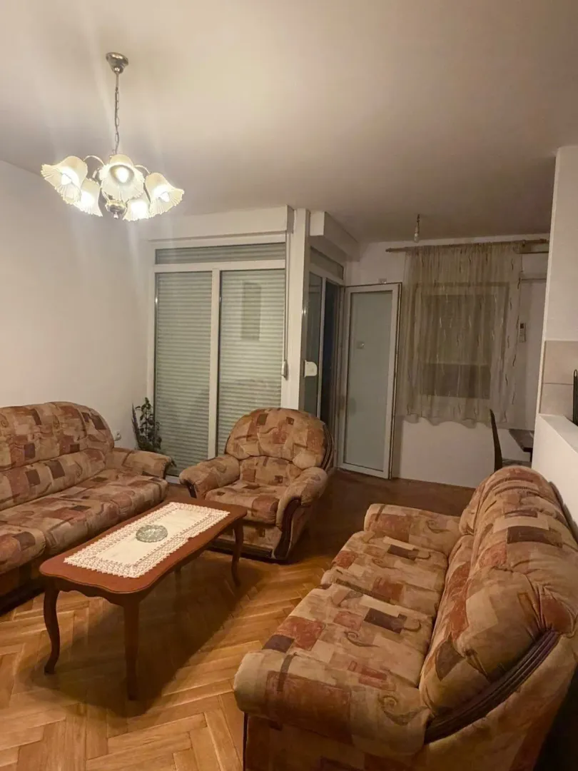 Dnevna soba sa garniturom za sjedenje, stočićem i izlazom na terasu.