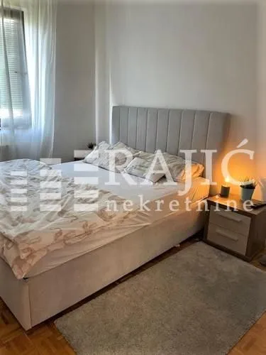 Furnished bedroom with a double bed and a nightstand.