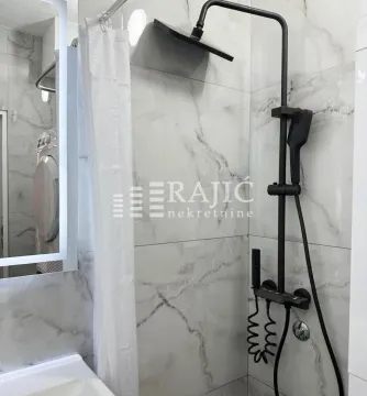 Modern black shower fixtures and marble tiles in the bathroom. - image 8
