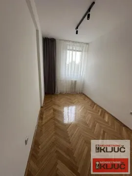 Prazna soba sa parketom i prozorom sa zavesama. - image 6