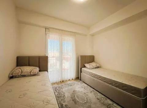 Furnished bedroom with two single beds and a rug. - image 5