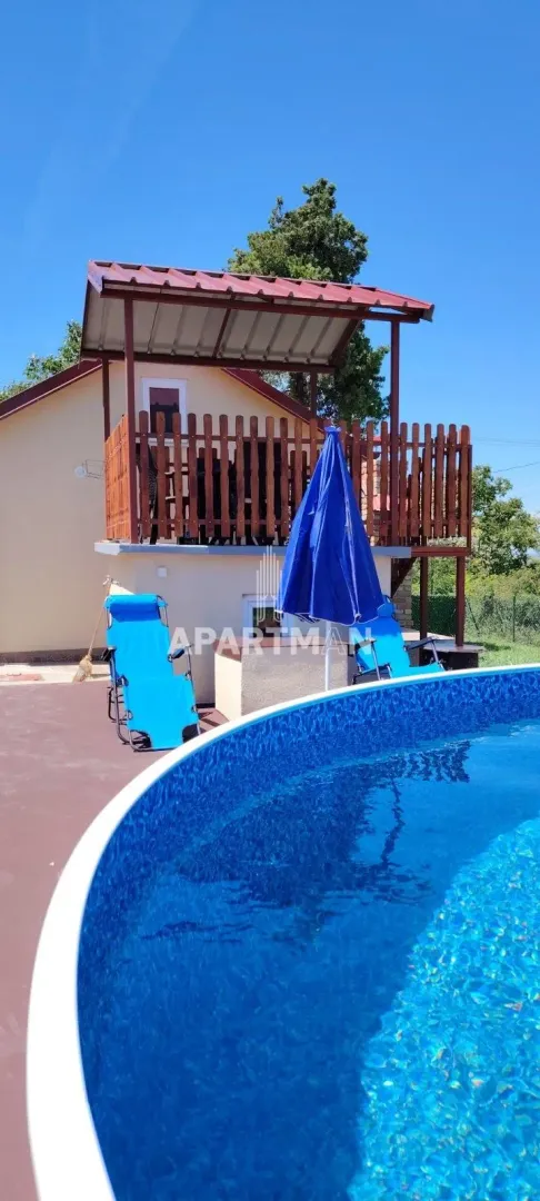 Pogled na bazen, dvorište i spoljašnjost kuće sa terasom.