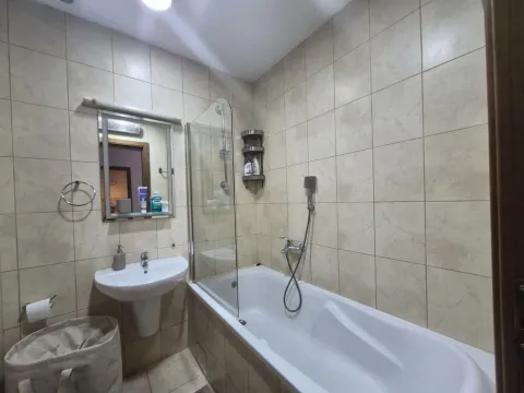 Small bathroom with a bathtub, washbasin, and mirror. - image 5