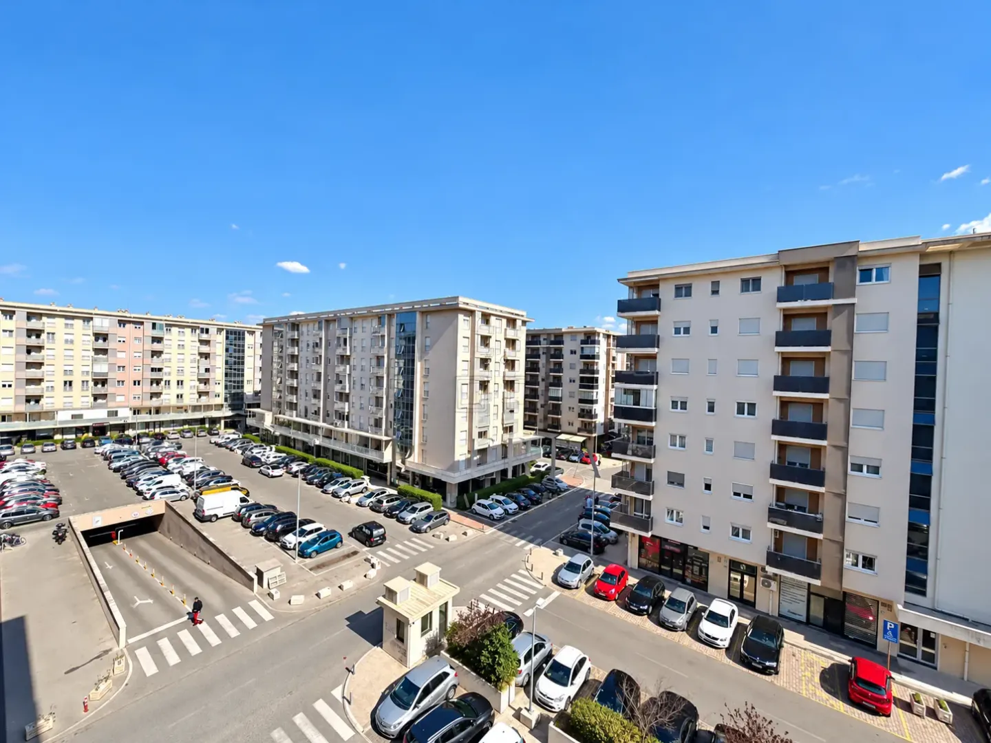 View from the terrace overlooking residential buildings and the parking lot in front.