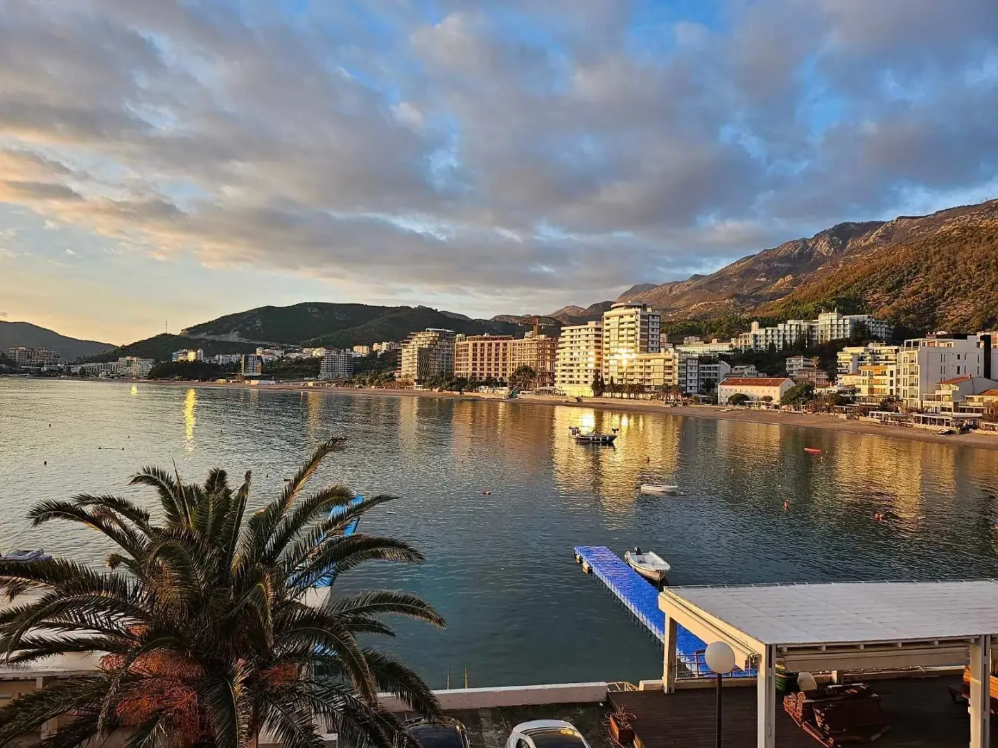 Pogled sa terase na grad, plažu i more u zalivu.