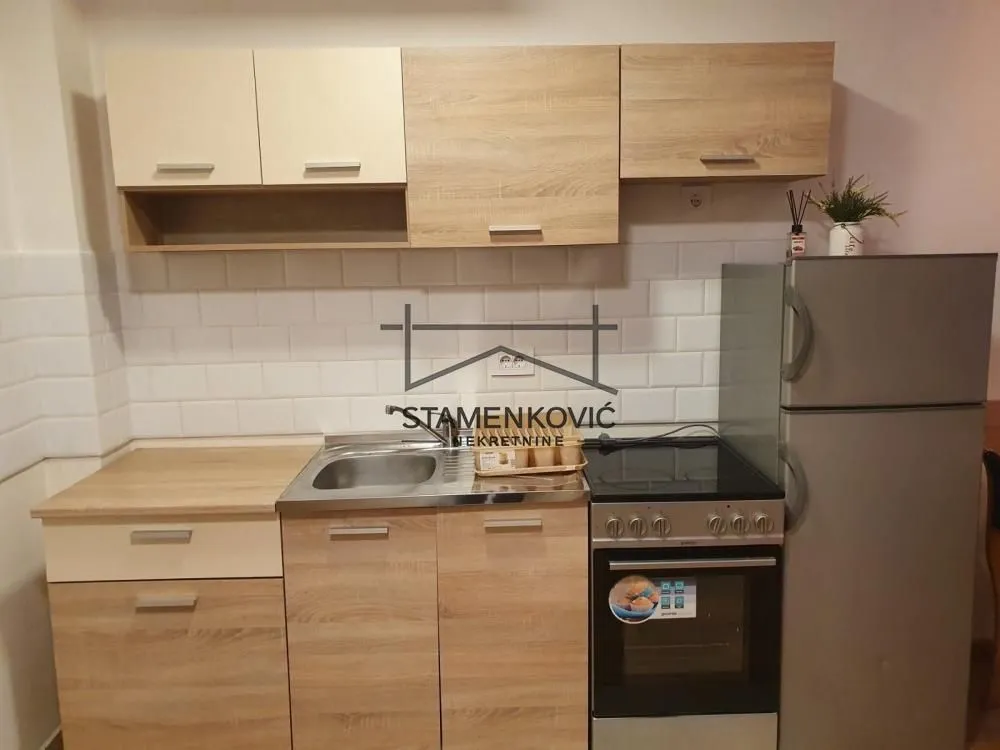Smaller kitchen with wooden cabinets, a stove, and a refrigerator.