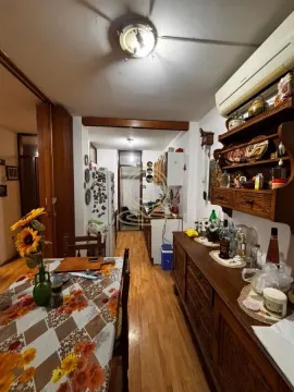 Dining area with a wooden table and a view of the kitchen in the background. - image 11